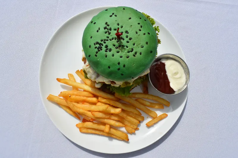 Hamburguesa de pan verde con papas fritas y salsa