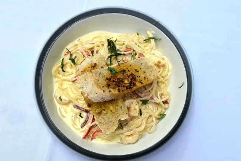 Pasta en salsa blanca con filete de pescado encima